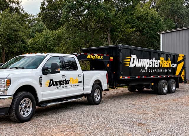 White pickup truck with Dumpster Flash branding next to a black Dumpster Flash dumpster trailer